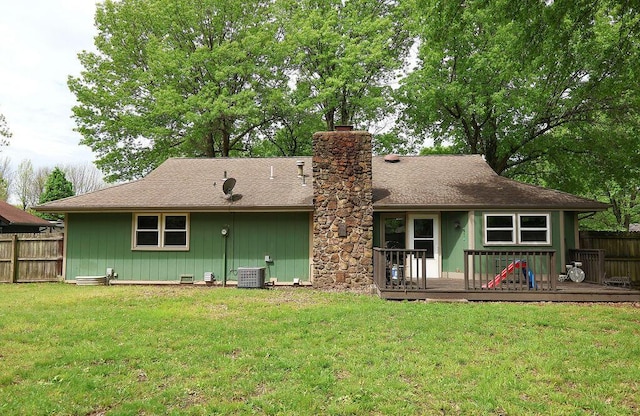 rear view of property featuring a lawn, a chimney, fence, and a deck
