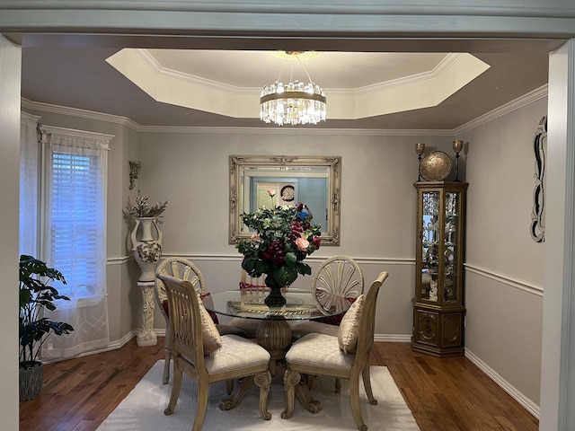 dining room featuring baseboards, a raised ceiling, a chandelier, and wood finished floors