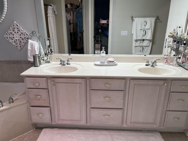 full bathroom featuring a sink, tile patterned flooring, double vanity, and a bath