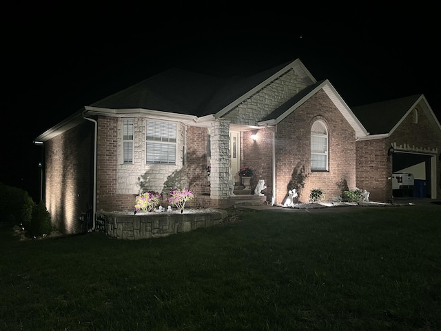 view of front of property featuring a lawn and brick siding