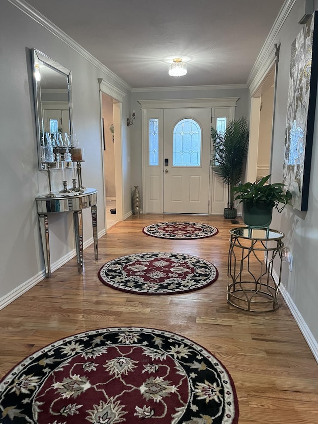 entryway featuring wood finished floors, baseboards, and ornamental molding