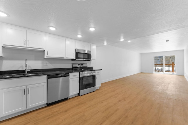 403 Veterans Blvd Unit 203 G6, Branson, MO 65616 - kitchen with light wood-type flooring, stainless steel appliances, baseboards, and a sink