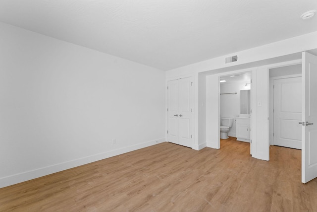 403 Veterans Blvd Unit 203 G6, Branson, MO 65616 - unfurnished bedroom featuring connected bathroom, light wood-type flooring, visible vents, and baseboards