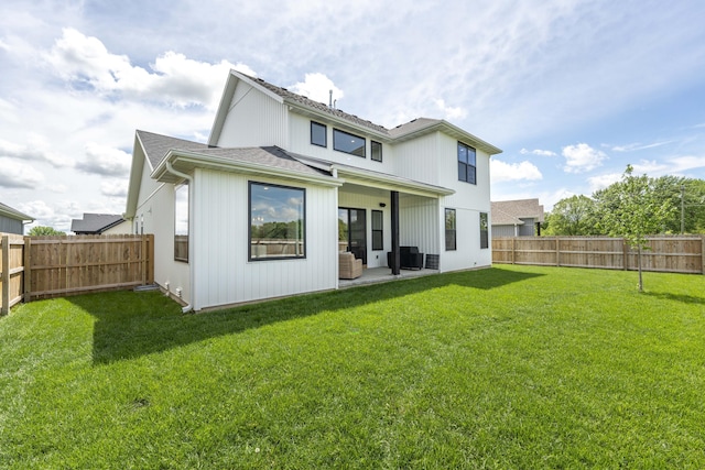 rear view of house featuring a lawn, a patio, and a fenced backyard
