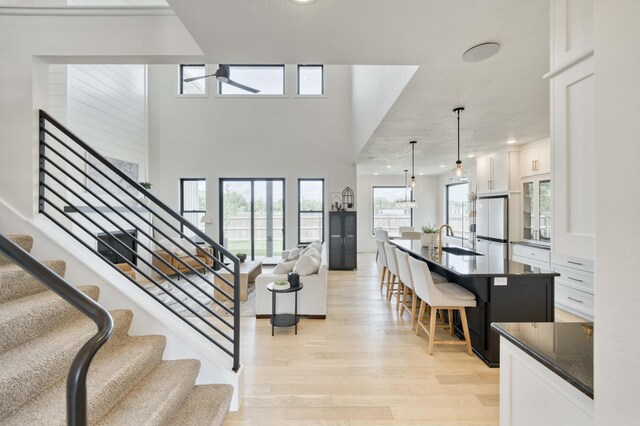 entrance foyer with ceiling fan, stairs, light wood finished floors, and recessed lighting