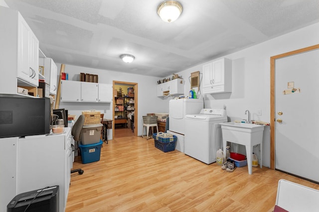 clothes washing area with laundry area, light wood-type flooring, and washer / clothes dryer