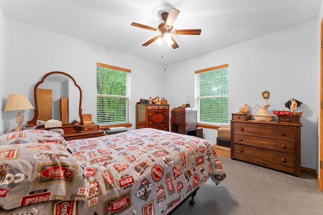 carpeted bedroom with a ceiling fan and multiple windows