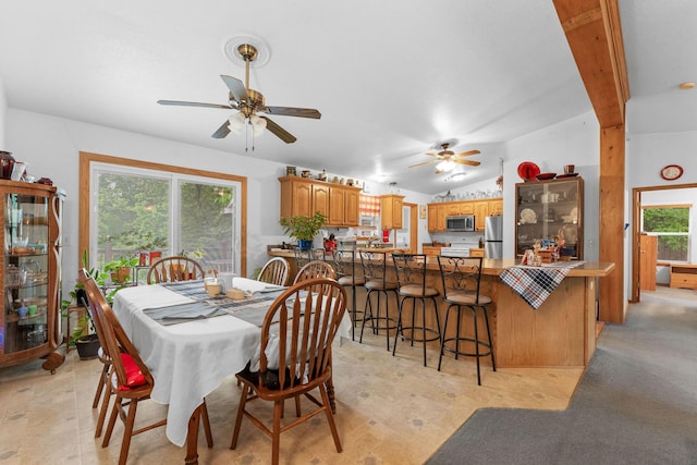 dining space with ceiling fan and vaulted ceiling