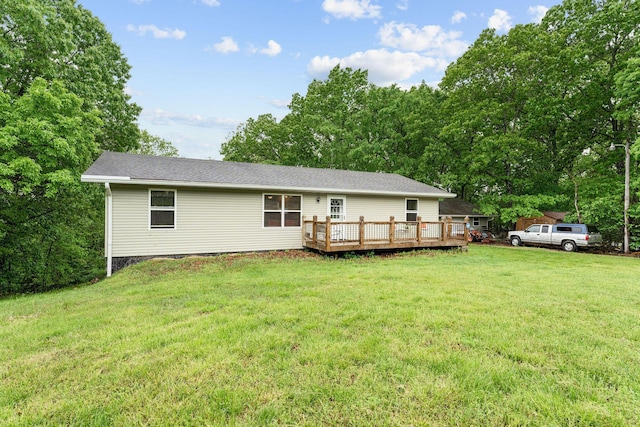 rear view of house featuring a lawn and a wooden deck