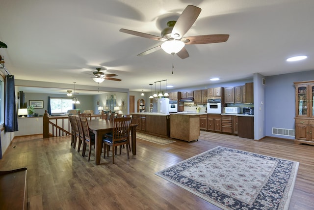 dining room featuring dark wood finished floors, visible vents, baseboards, and ceiling fan