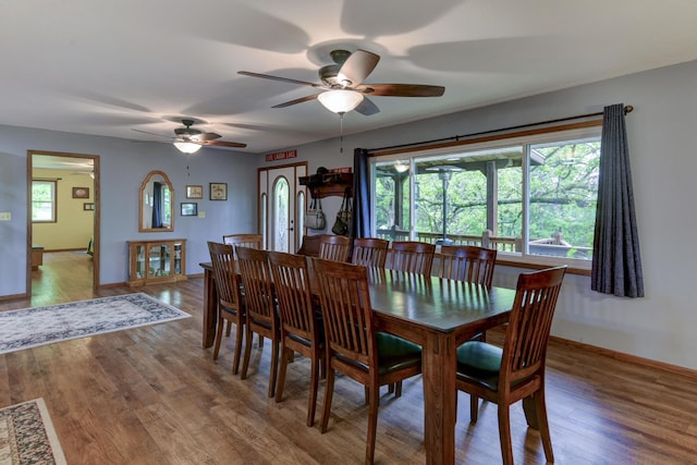 dining room with baseboards, ceiling fan, and wood finished floors