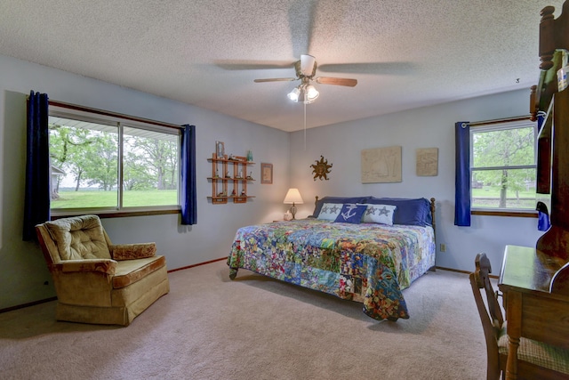 bedroom featuring baseboards, a textured ceiling, ceiling fan, and carpet