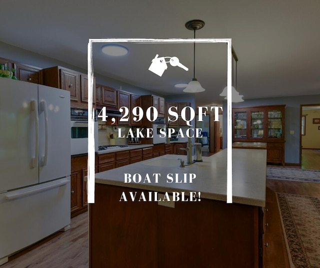 26742 Royal Point Dr, Shell Knob, MO 65747 - kitchen featuring white appliances, wood finished floors, a sink, and pendant lighting