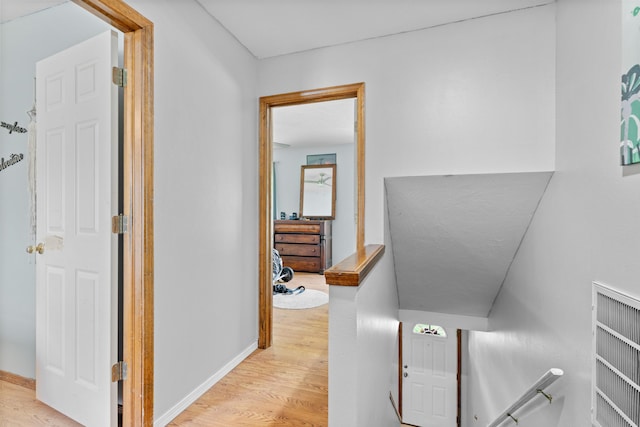 hallway featuring baseboards and light wood-style floors