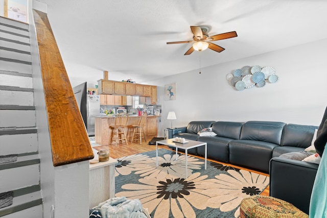 living area with light wood-type flooring and a ceiling fan