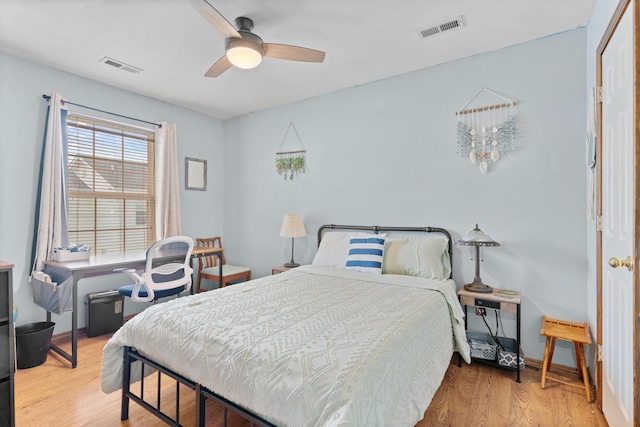 bedroom with baseboards, visible vents, wood finished floors, and a ceiling fan
