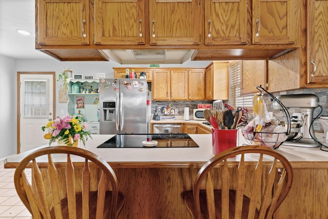 kitchen featuring light countertops, stainless steel appliances, tasteful backsplash, and a healthy amount of sunlight