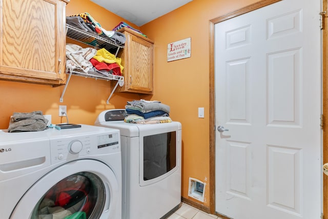 laundry room with light tile patterned floors, separate washer and dryer, and cabinet space