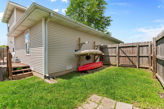 exterior space featuring a yard, a wooden deck, and fence