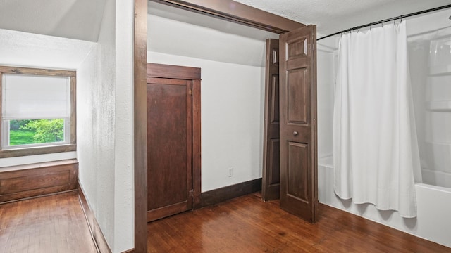 hall with dark wood finished floors, baseboards, and a textured ceiling