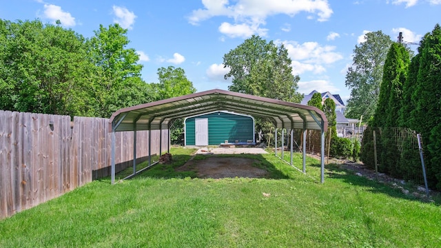 view of yard featuring fence, a carport, and driveway