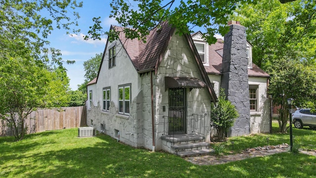 view of front of home featuring a front yard, a shingled roof, and fence