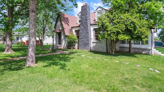 view of home's exterior featuring a lawn and a chimney