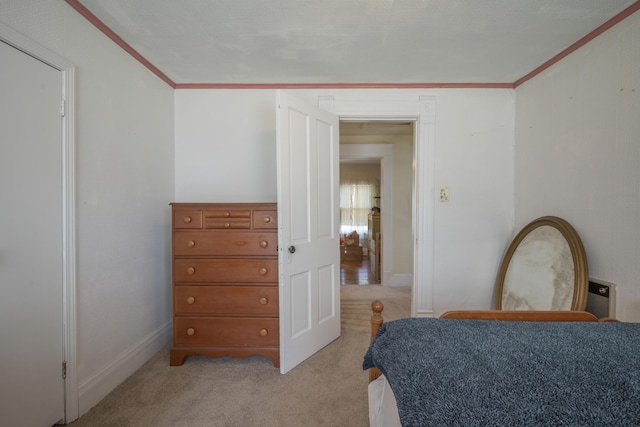 bedroom featuring baseboards, light carpet, and crown molding