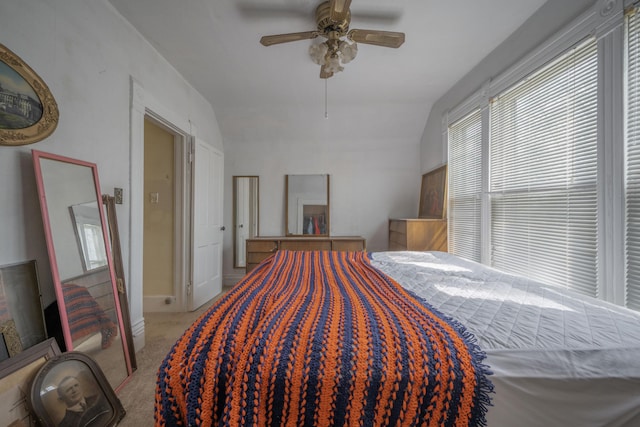 carpeted bedroom featuring vaulted ceiling and a ceiling fan