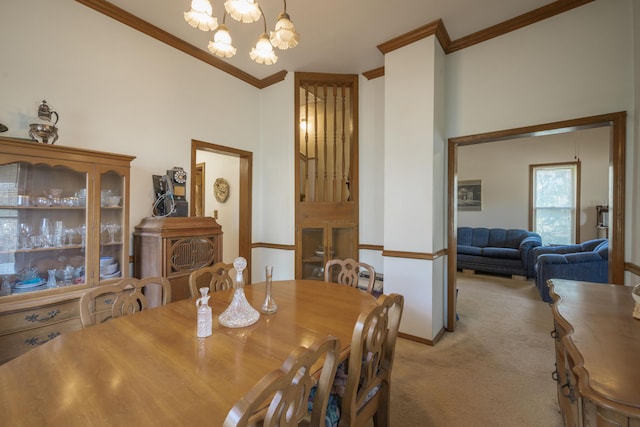 carpeted dining space featuring baseboards, a chandelier, and crown molding