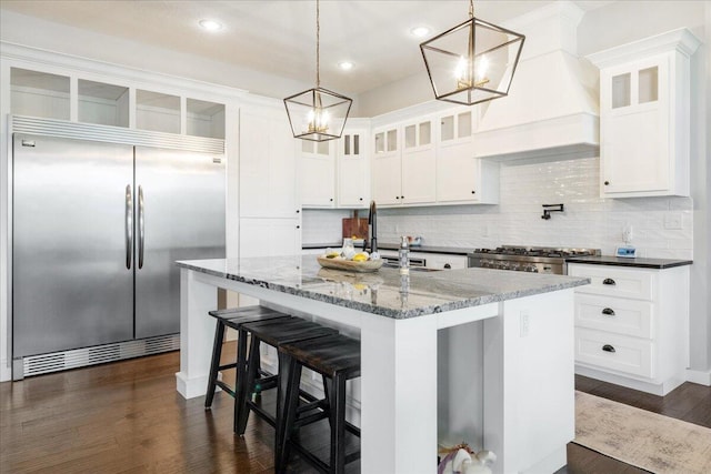 kitchen featuring a notable chandelier, stainless steel built in fridge, a sink, and tasteful backsplash
