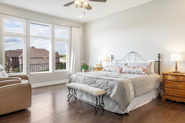 bedroom with a ceiling fan, wood finished floors, and baseboards