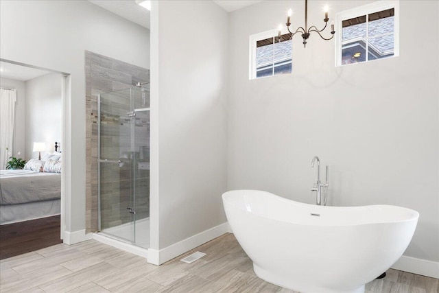 bathroom with a stall shower, ensuite bathroom, baseboards, and a freestanding bath