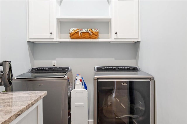 washroom with washing machine and clothes dryer and cabinet space
