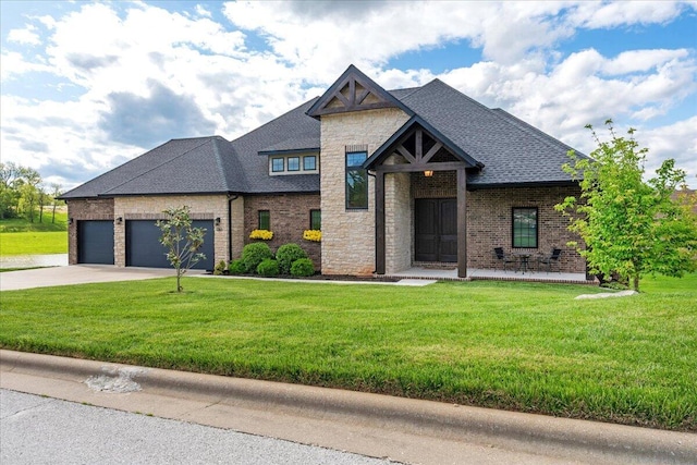 view of front of property featuring stone siding, a garage, concrete driveway, a front yard, and brick siding