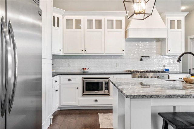 kitchen with white cabinetry, dark wood-style flooring, appliances with stainless steel finishes, and custom range hood