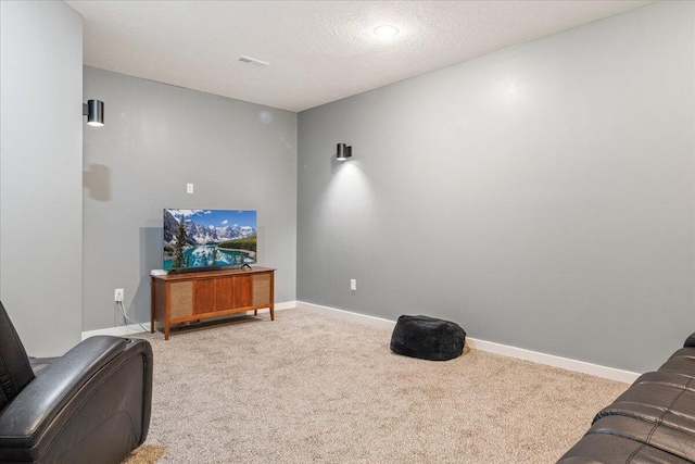 interior space with a textured ceiling, carpet flooring, baseboards, and visible vents