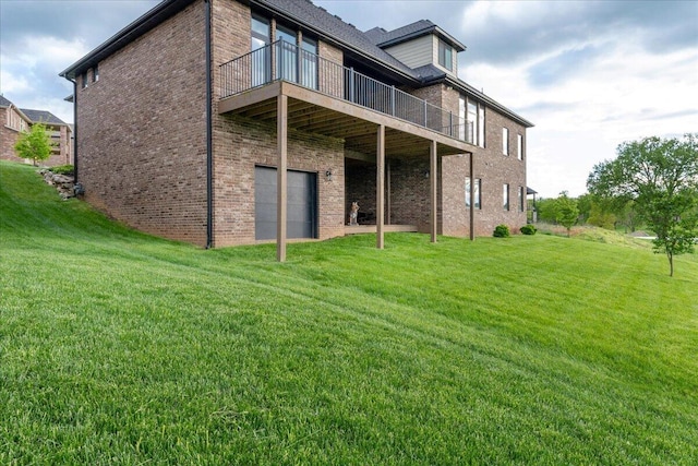 rear view of property with a yard, brick siding, and a garage