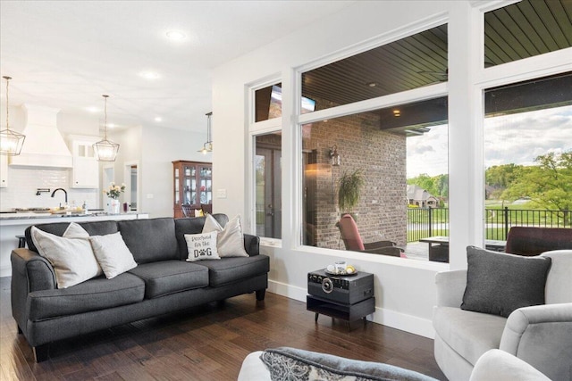 living room featuring dark wood-style flooring, recessed lighting, and plenty of natural light