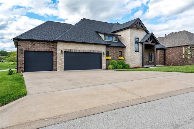 view of front of property with an attached garage, a shingled roof, a front yard, brick siding, and driveway