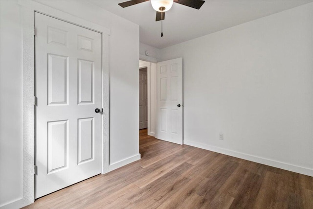 unfurnished bedroom featuring ceiling fan, baseboards, and light wood-style floors