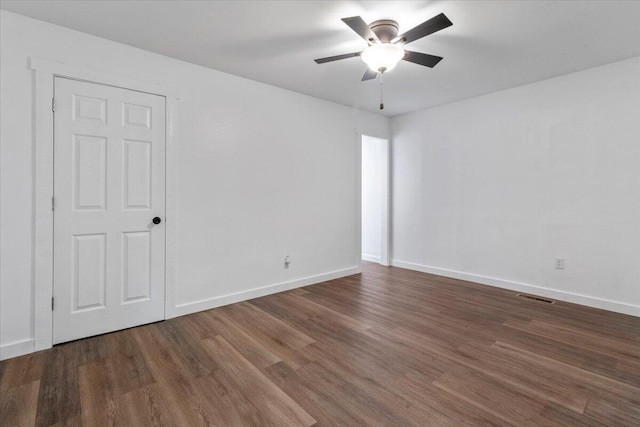 unfurnished room featuring a ceiling fan, baseboards, visible vents, and wood finished floors
