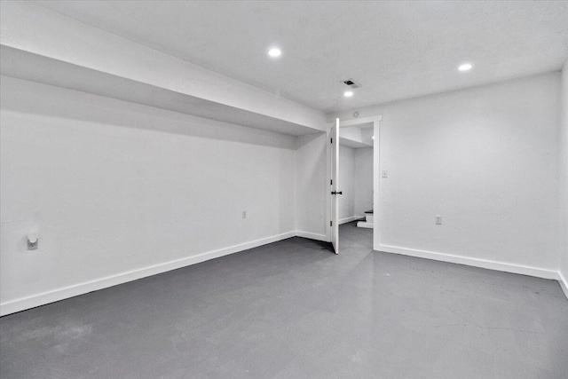 finished below grade area featuring baseboards, visible vents, and recessed lighting
