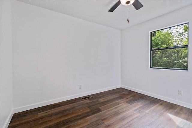 empty room with dark wood finished floors, visible vents, baseboards, and ceiling fan