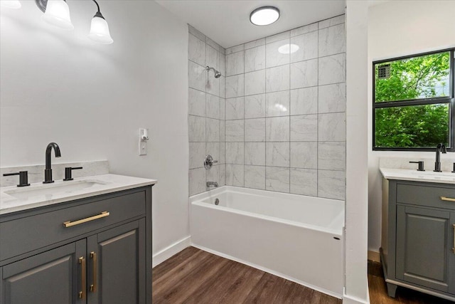 full bath with vanity, tub / shower combination, baseboards, and wood finished floors