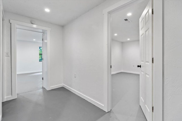 hallway featuring recessed lighting, baseboards, visible vents, and concrete floors