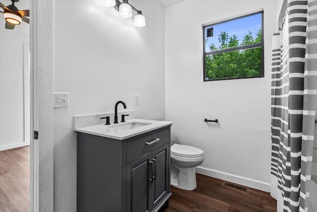 full bathroom with toilet, wood finished floors, visible vents, baseboards, and vanity