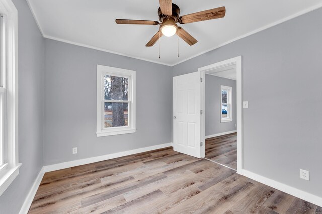 unfurnished bedroom with baseboards, ornamental molding, and wood finished floors