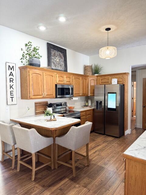 1118 E Ritter St, Republic, MO 65738 - kitchen featuring a peninsula, wood finished floors, stainless steel appliances, decorative light fixtures, and light countertops