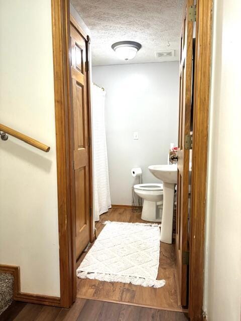 1118 E Ritter St, Republic, MO 65738 - full bathroom featuring toilet, wood finished floors, a textured ceiling, visible vents, and baseboards